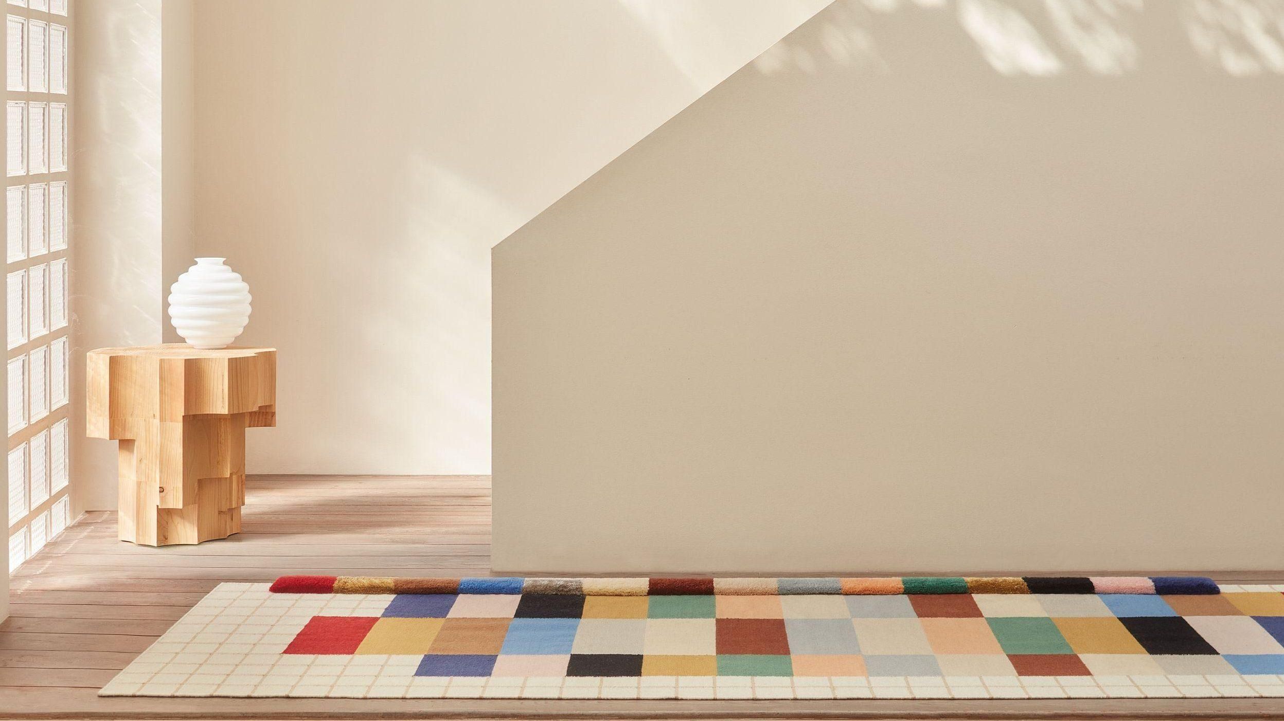 Alfombra de diseño en salón contemporáneo de Vitoria con sofá de diseño y iluminación cálida